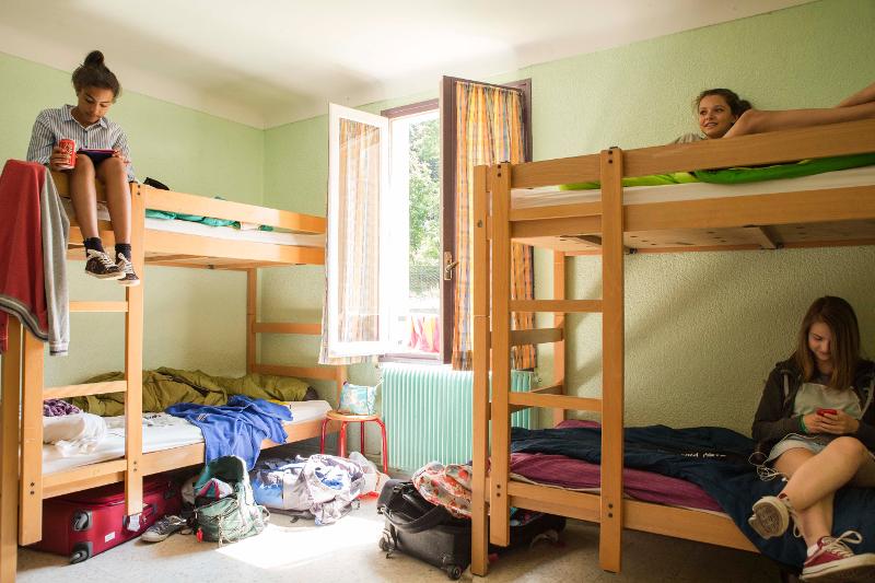 des ado font une pause dans leur chambre en colonie de vacances occitanie 