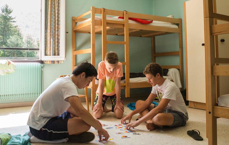 des jeunes jouent aux cartes dans la chambre d'une colonie de vacances occitanie 