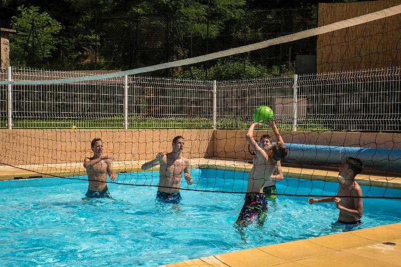 Des jeunes jouent au volley dans la piscine d'une colonie de vacances occitanie 
