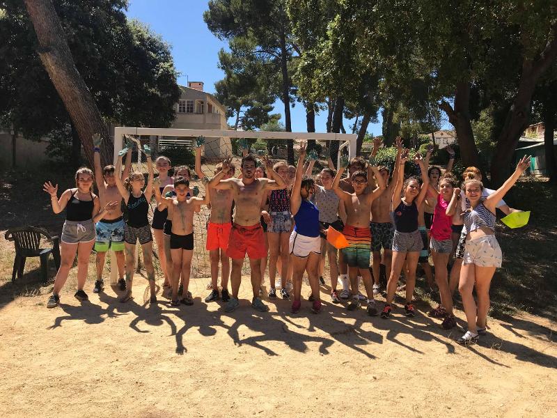 groupe avec les mains en l'air en maillots de bain en colo france