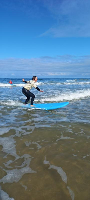 Une fille faisant du surf lors d'une colonie de vacances voile