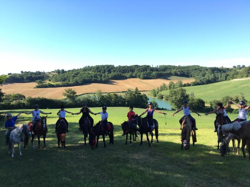 Un groupe de cavalier de la colonie de vacances équitation posent dans un champs pour la photo