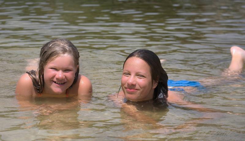 Deux ados nagent dans la rivière en colonie de vacances équitation