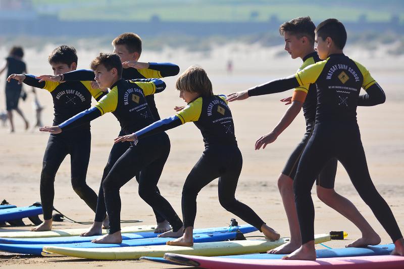des ado pendant un cours de surf en colonie de vacances espagne