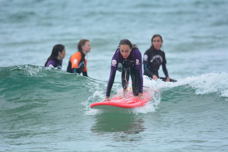 une ado s'apprête à surfer sur une vague en colonie de vacances espagne