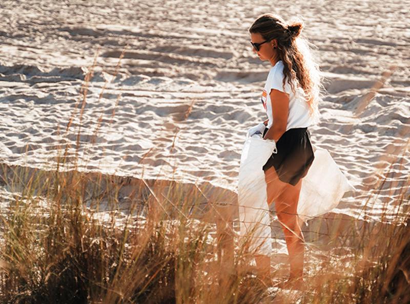 fille qui nettoie la plage en colonie ado