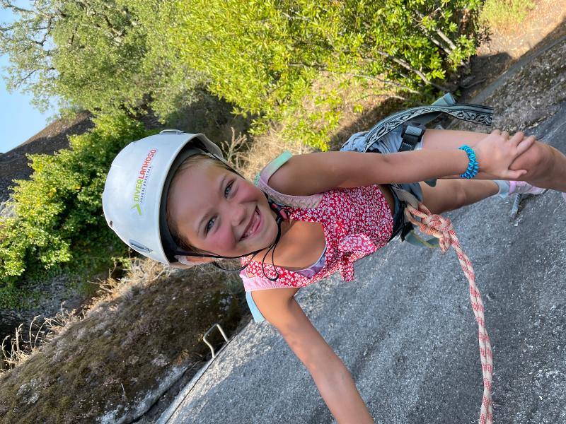 petite fille avec un casque en colonie de vacances accrobranche
