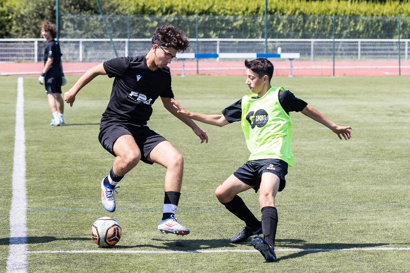 Deux jeunes qui jouent sur le terrain lors d'un stage de foot Bretagne