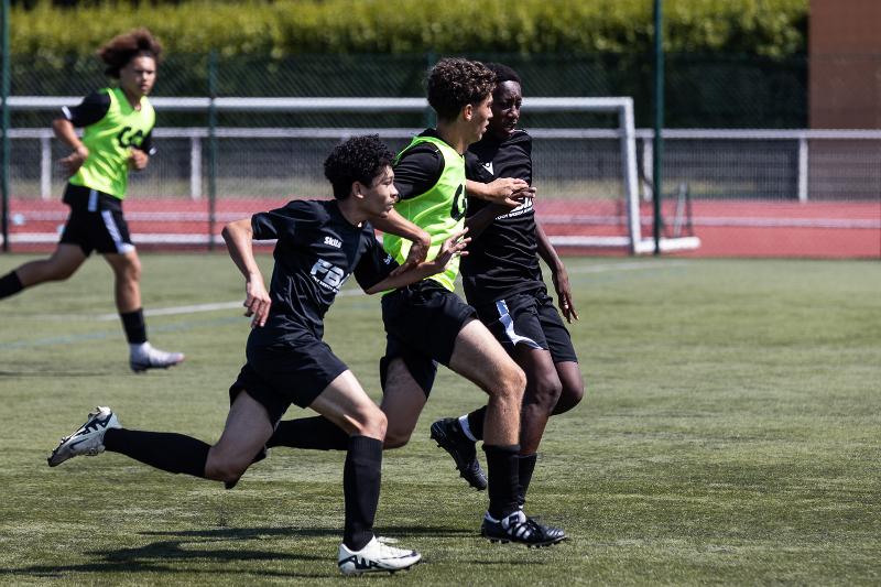 Quatre jeunes qui courent sur le terrain lors d'un stage foot bretagne