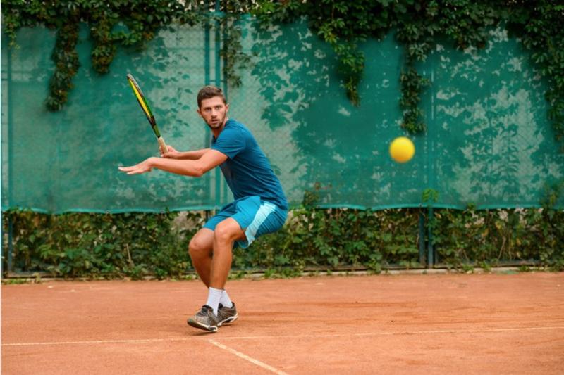homme adulte concentré jouant du tennis 