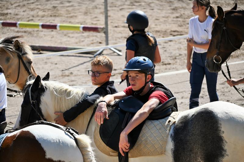 Un garçon monte en selle en colonie de vacances passage gallop