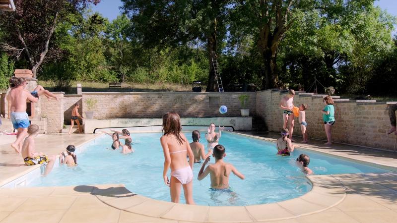 Enfants qui s'amusent dans une piscine lors d'une colo été