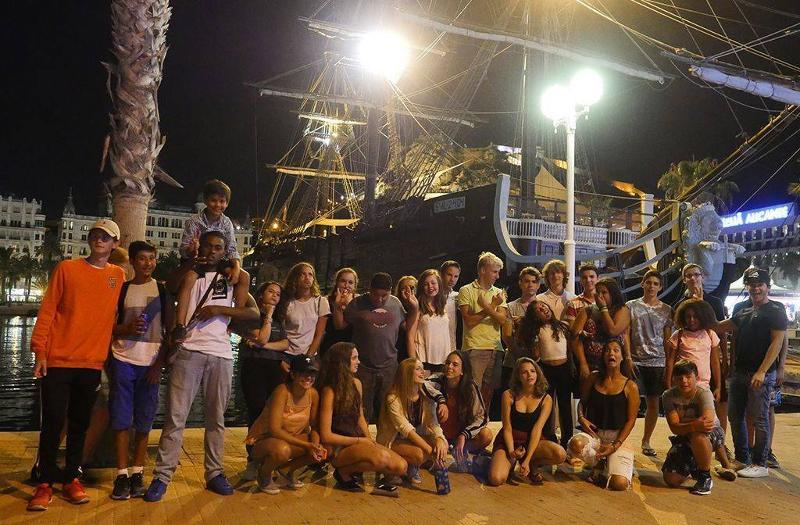 groupe devant un bateau dans la nuit en séjour linguistique Barcelone