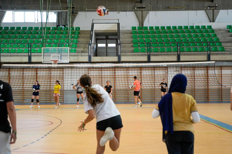 adolescente qui tire dans un match de volleyball en intérieur après les cours en séjour de langue espagnol
