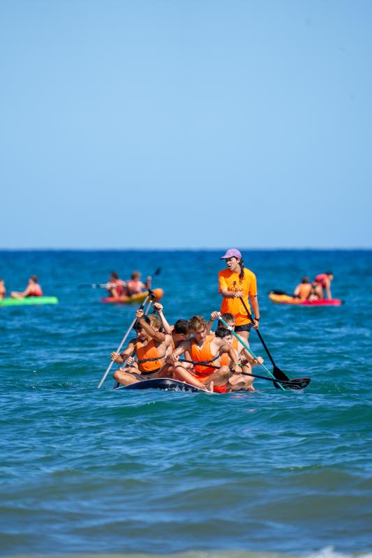 groupe de jeunes qui font du paddle sur la mer en colo