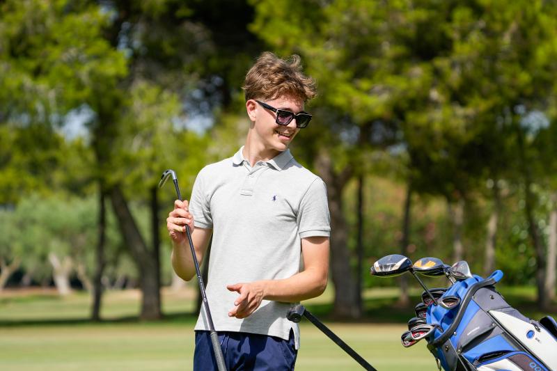 jeune heureux avec un club de golf en stage de langue espagnol