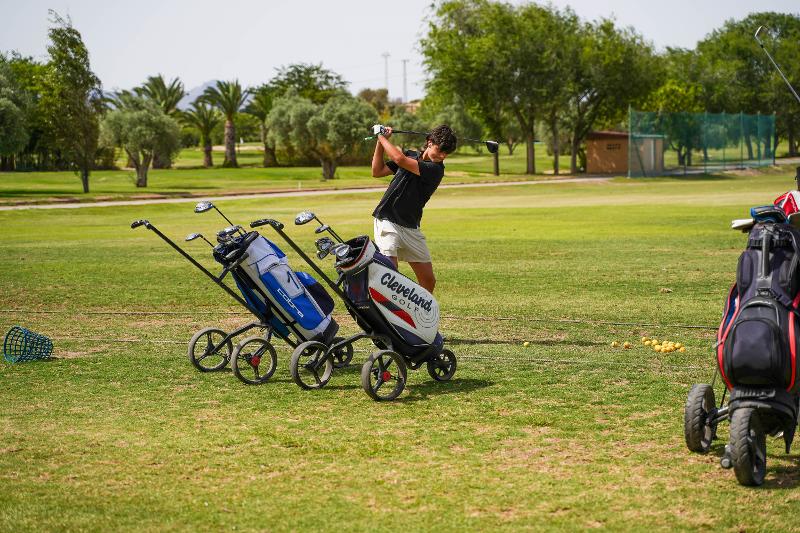 jeune garçon qui joue au golf avec tout le matériel nécessaire sur un terrain en stage de langue espagnol