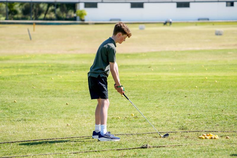 jeune qui prépare un swing sur un terrain de golf en stage de langue espagnol