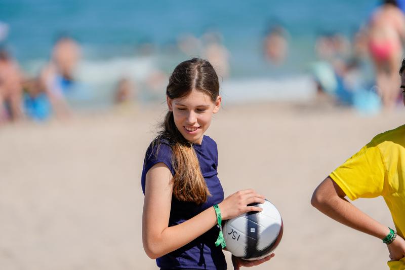 jeune fille avec un ballon de volleyball sur la plage en stage de langue espagnol