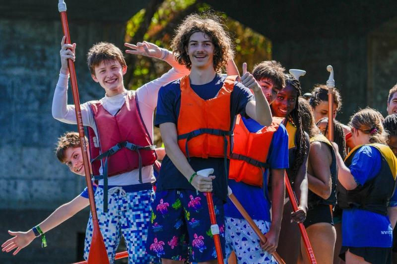 groupe jeunes heureux avec des gilets de sauvetages qui commencent une activité nautique