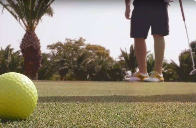 photo du bas avec des chaussures et une balle de golf près de la caméra