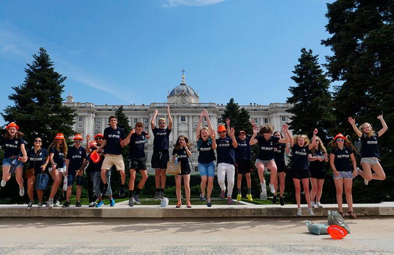 Un groupe de personnes en séjour linguistique Madrid saute devant un monument à Madrid 