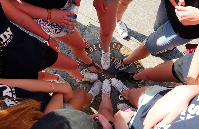 groupe de jeunes en colo qui prennent leurs chaussures en photo