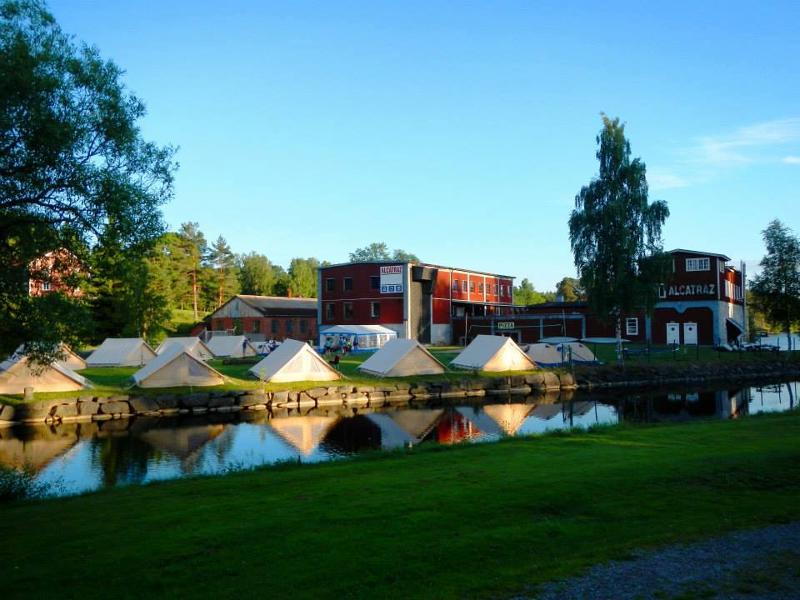Vue sur le campement de la colo aventure en Suède, sur l'herbe près d'un canal