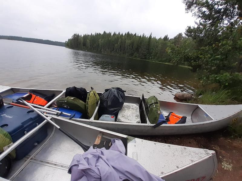 Deux canoës sur le bord de l'eau remplis de tentes et d'affaires lors du camp itinérant en Suède