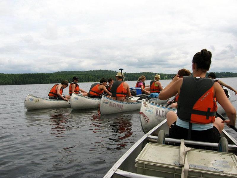 Jeunes en canoë naviguant côte à côte pendant le camp itinérant en Suède