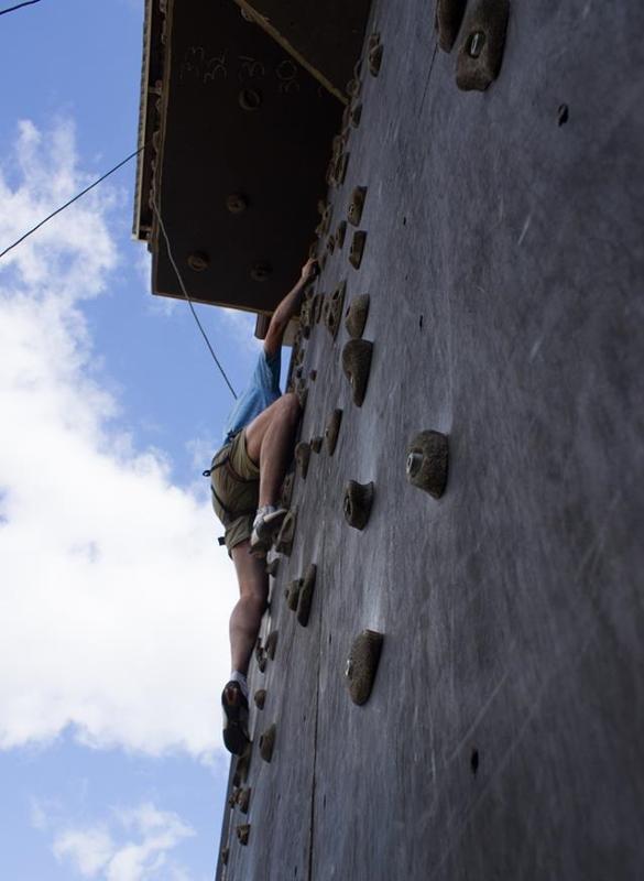 Jeune grimpant sur un mur d'escalade en plein air pendant la colo aventure en Suède