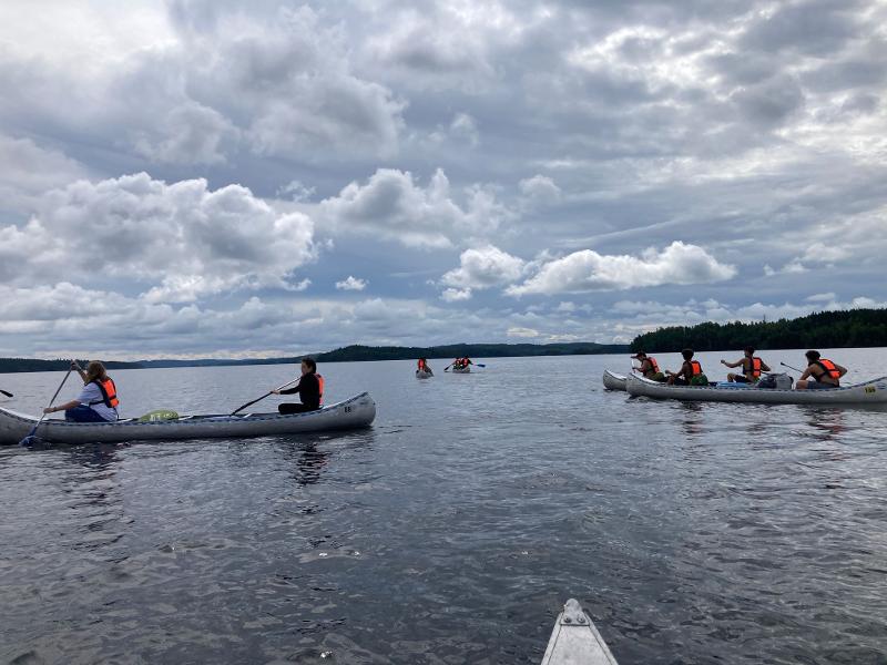 Vue sur les canoës dans l'eau sous un ciel bleu nuageux pendant le camp itinérant en Suède