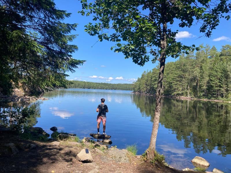 Jeunes sur un rocher dans le lac, regardant au loin pendant le camp itinérant en Suède