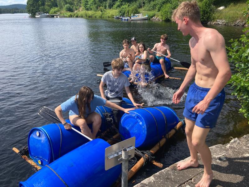Jeunes accostant sur la rive sur les radeaux qu'ils ont fabriqué pendant la colo aventure en Suède