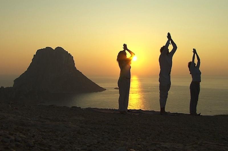 trois personnes qui font du yoga en face d'une superbe vue 