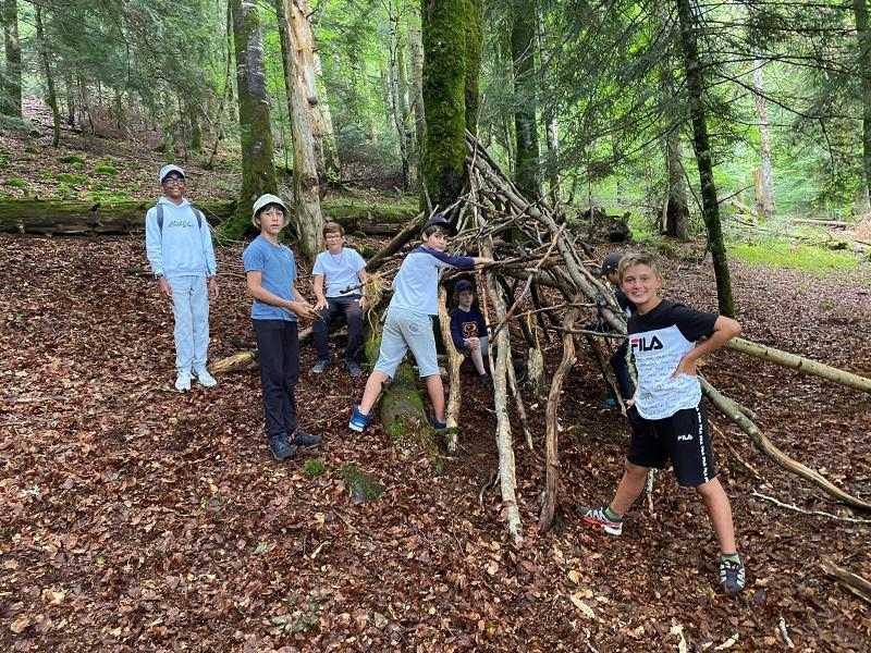 jeunes qui construisent une cabane dans les bois en colo