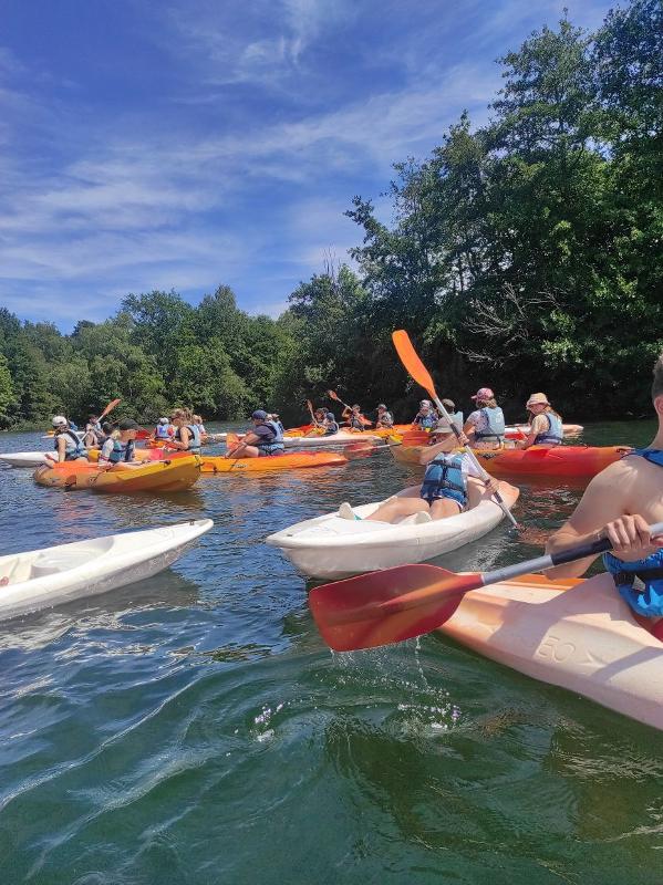 jeunes en colo dans des kayaks sur un lac