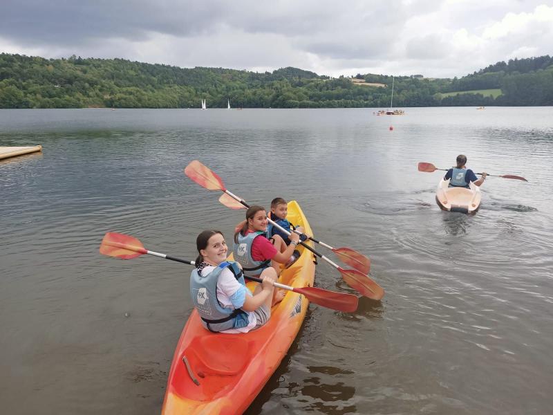 trois jeunes dans un canoe sur un lac en colo