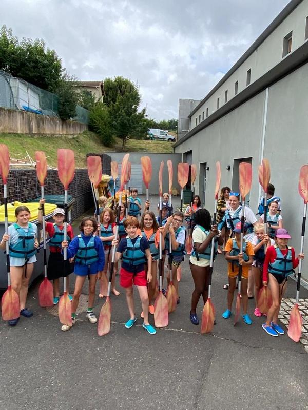 groupe de jeunes en colo qui vont faire du canoe avec leurs rames