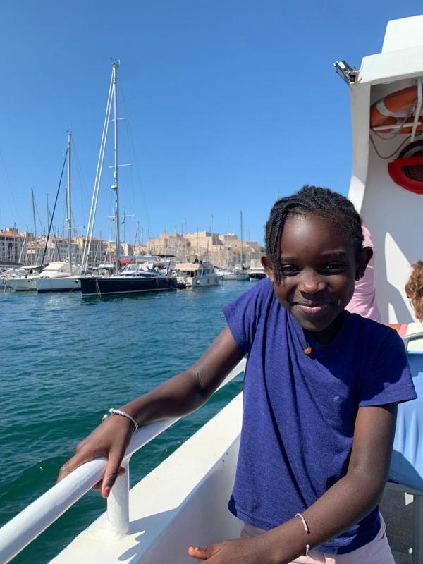 jeune fille heureuse sur un bateau en colo été à la mer