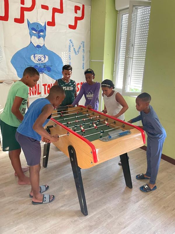 groupe de jeunes qui jouent au babyfoot en colo