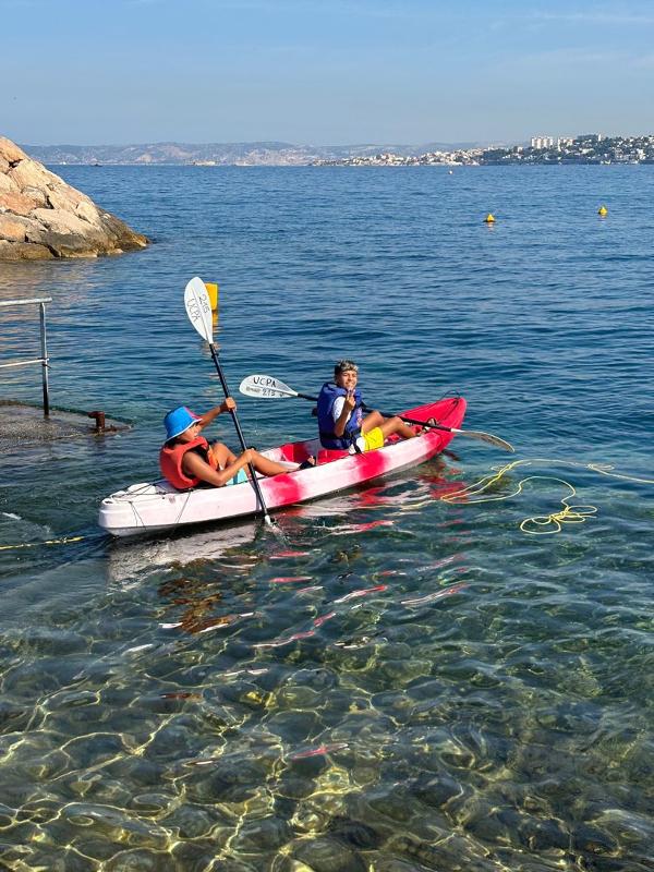 deux ados sur un kayak rose sur la mer en colo