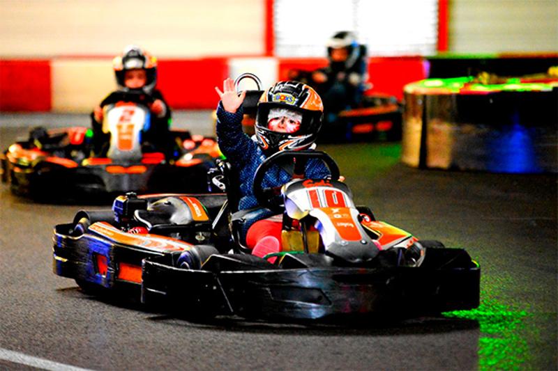 jeune garçon avec un casque dans une voiture de karting lors d'une colo