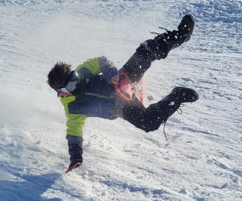 ado qui fait des figures en luge dans la neige lors d'une colo de ski