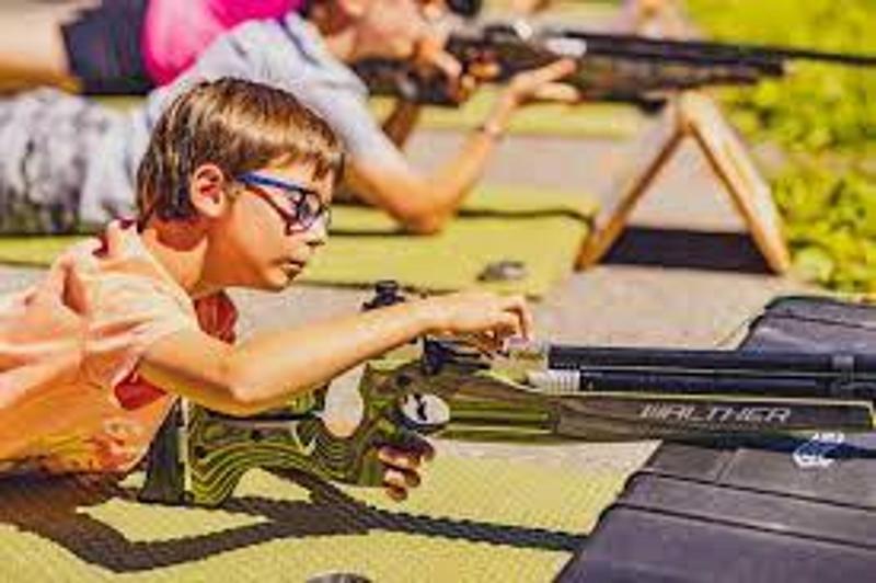 enfant lors d'une colo biathlon qui apprend à tirer à la carabine