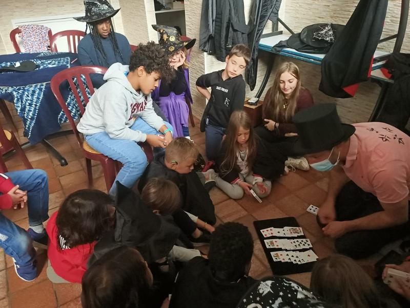 jeunes en cercle qui font des jeux de carte lors d'une colo magique