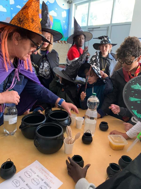 groupe de jeunes qui font des potions déguisés en sorcier lors d'une colo magique