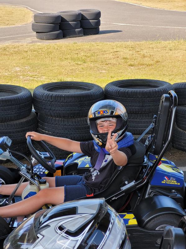 jeune en colo qui est heureux de faire du karting