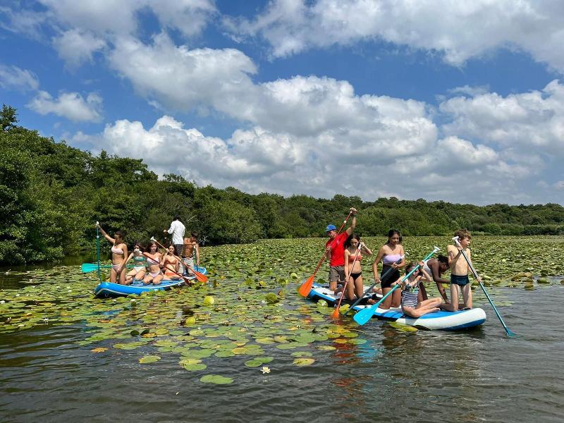 jeunes sur des paddles en colo sur un lac