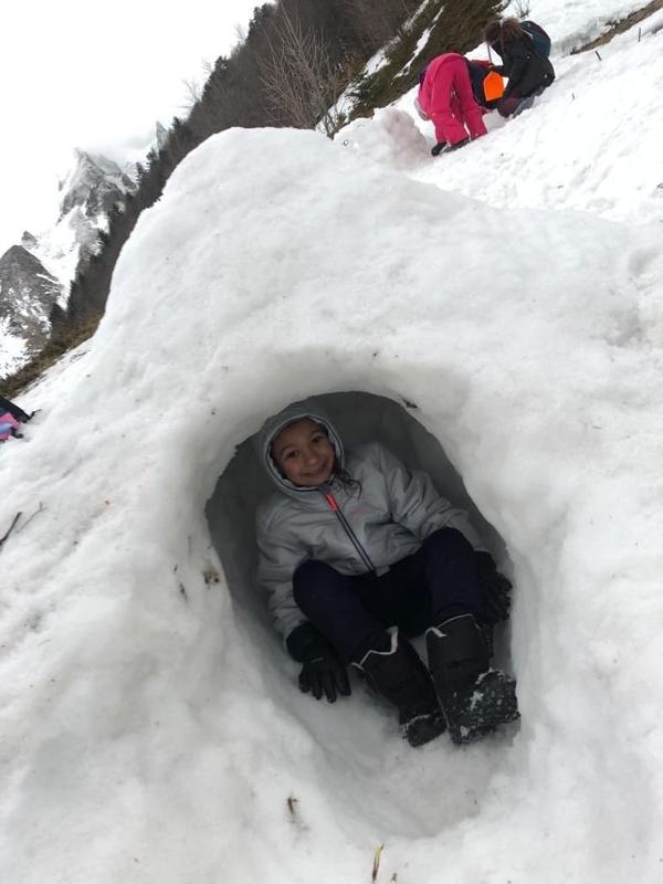 enfant dans un igloo dans la neige en colo